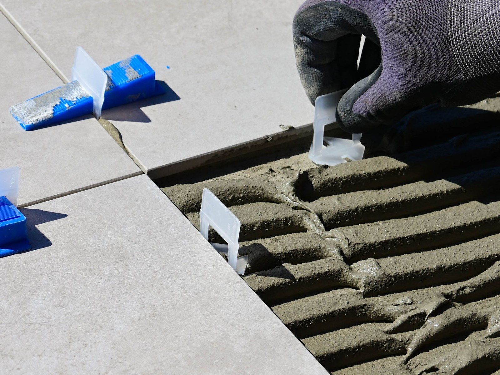 Large-format floor tile installation with leveling clips (stock image)